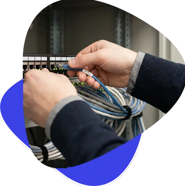 Technician patching a labelled network cable into a switch